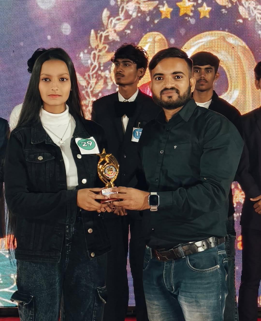 Students posing with a trophy on stage